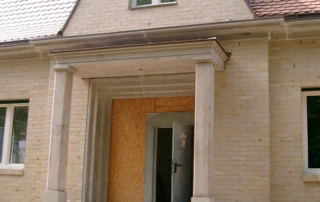 Sichtbeton-Türgewände, Gesimsteile, Ziergiebel und Vordach mit Stahlbetonstützen für den Neubau eines Einfamilienhauses in Berlin